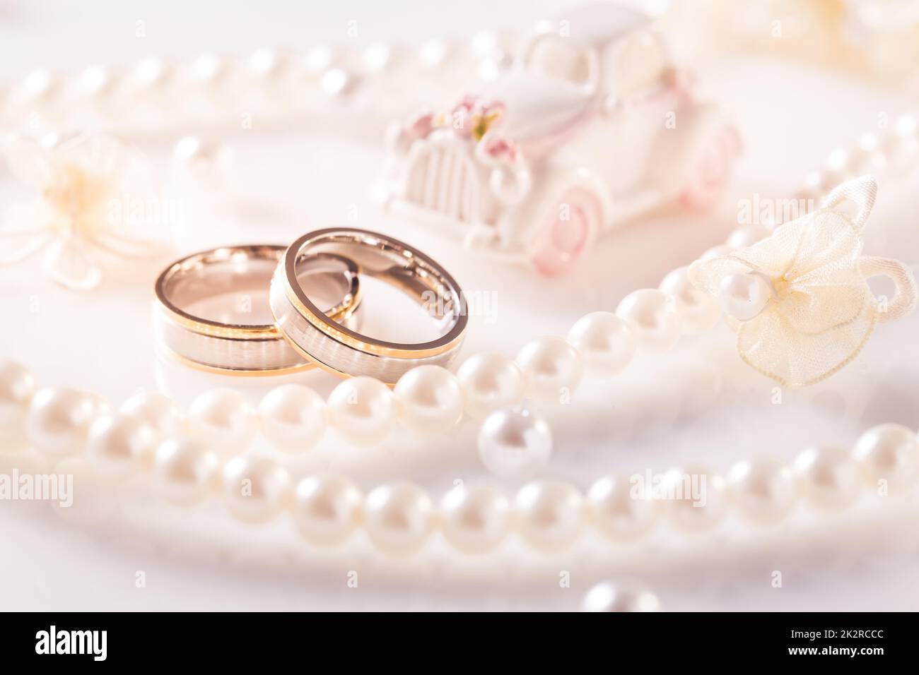 Hochzeit Stillleben mit goldenen Ringen und Perlenkette in weiß Stockfoto