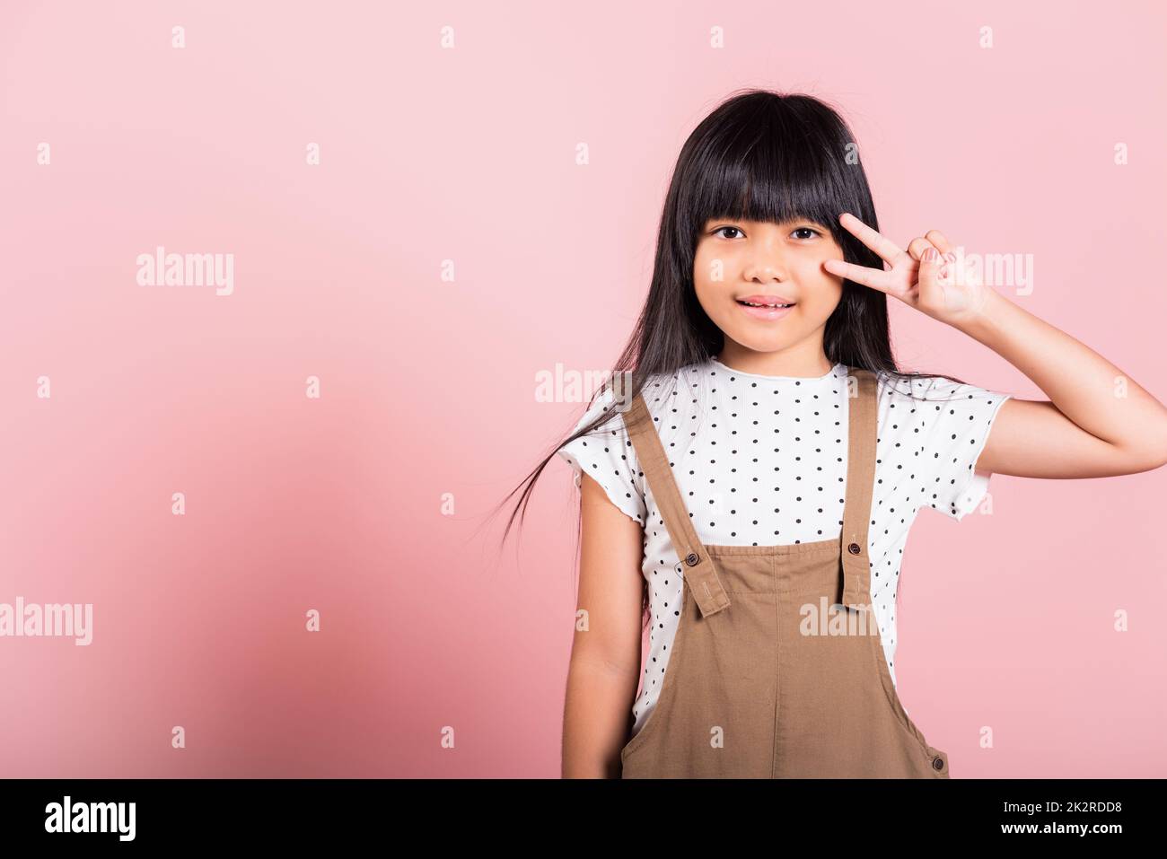 Asiatisches kleines Kind 10 Jahre alt zeigt V-Zeichen-Finger-Geste Stockfoto