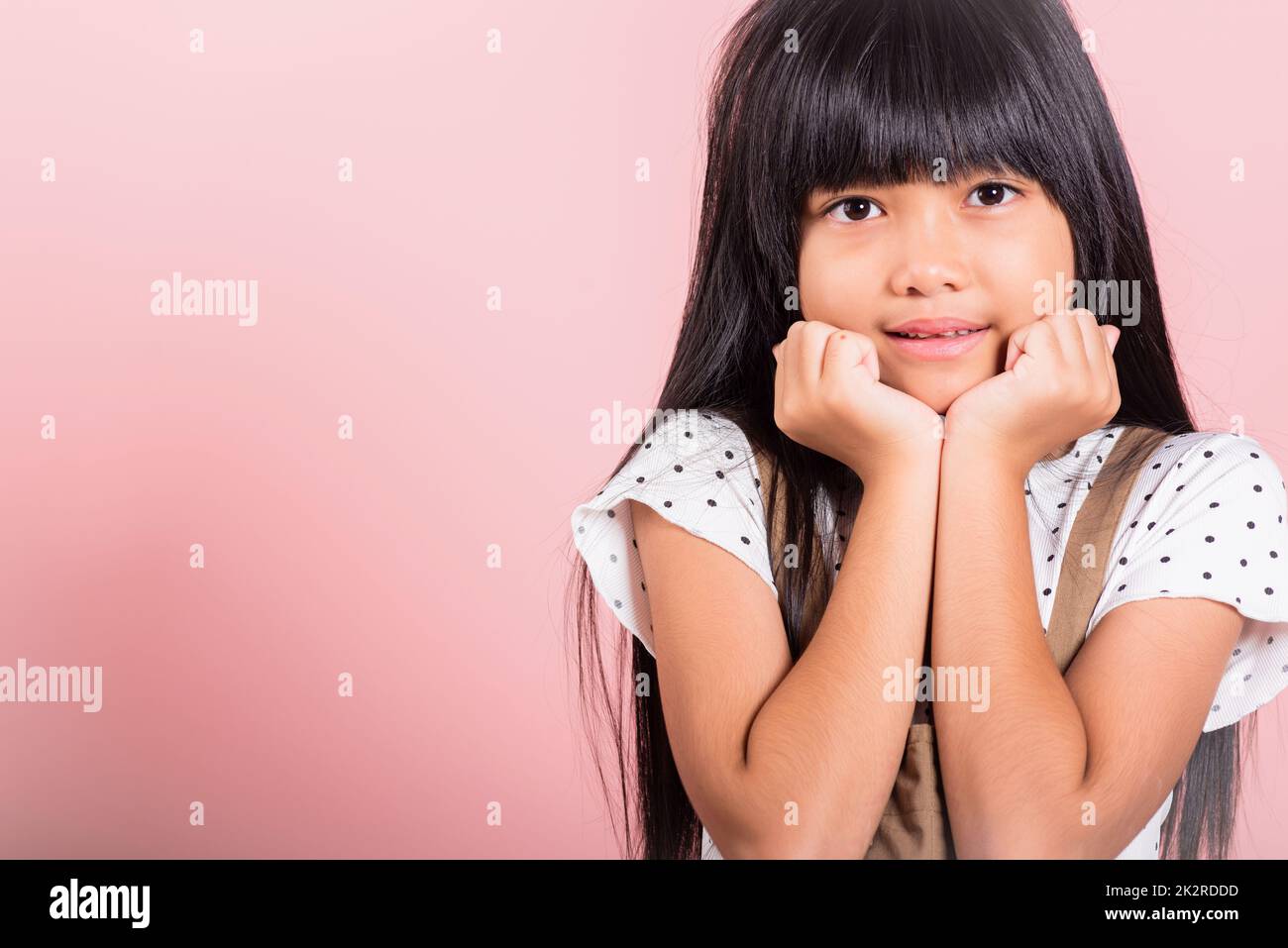 Asiatisches kleines Kind, 10 Jahre alt, Hände berühren Kinn, denken Traum Stockfoto