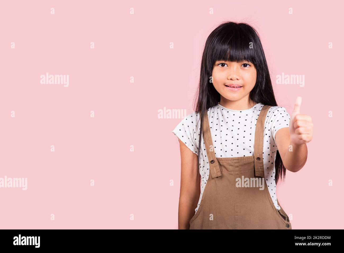 Asiatisches kleines Kind, 10 Jahre alt, zeigt Daumen nach oben Stockfoto