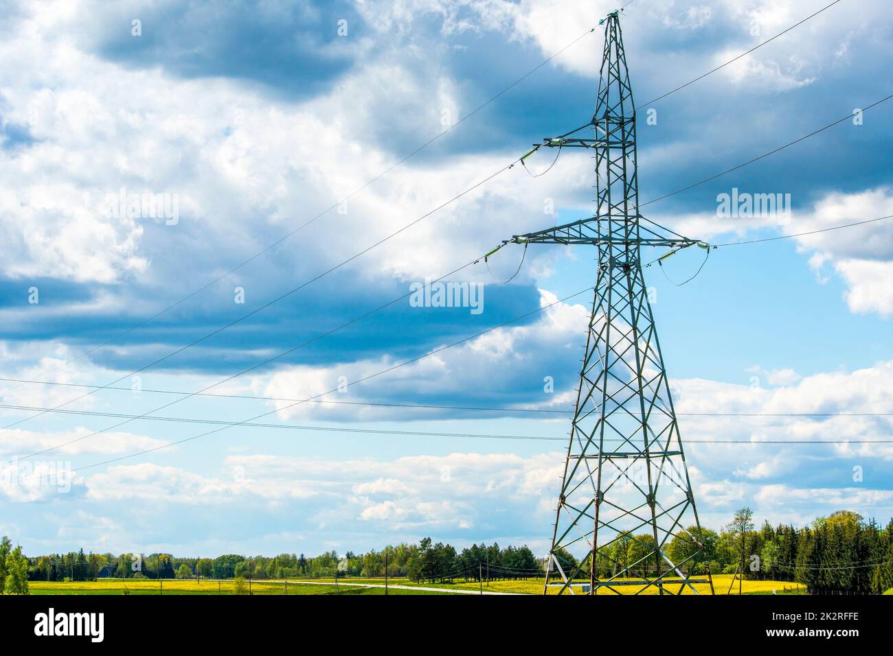Kraftübertragungsleitungen und hoher Strompylon vor dem blauen Himmel auf dem Land Stockfoto