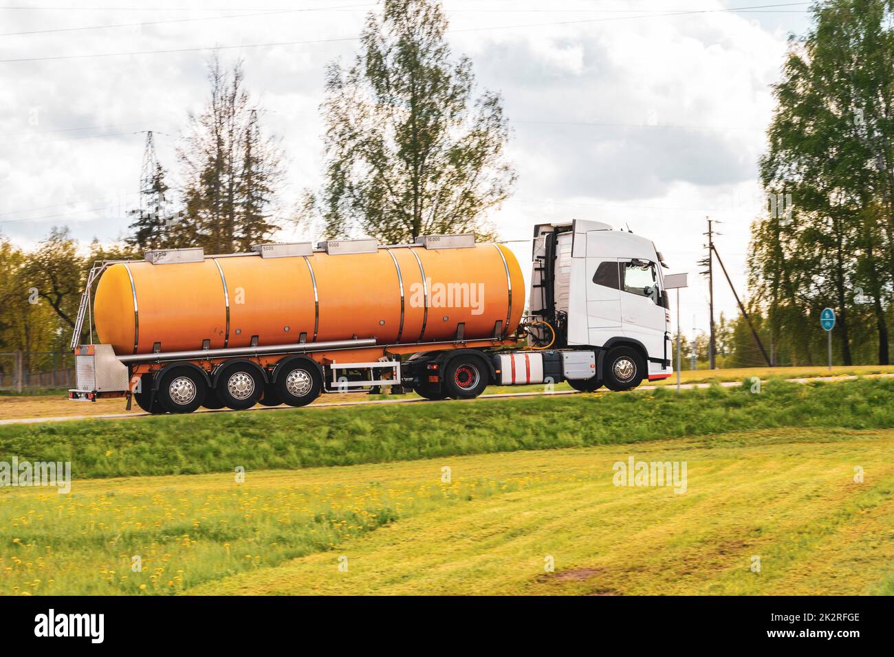 Lastwagen mit orangefarbenem Tankwagen auf einer Straße Stockfoto