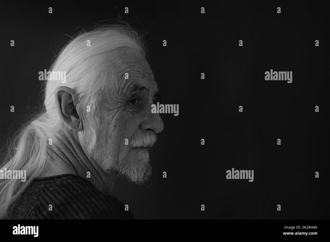 Schwarz-Weiß-Porträt eines alten Mannes, der über seine Schulter schaut Stockfoto