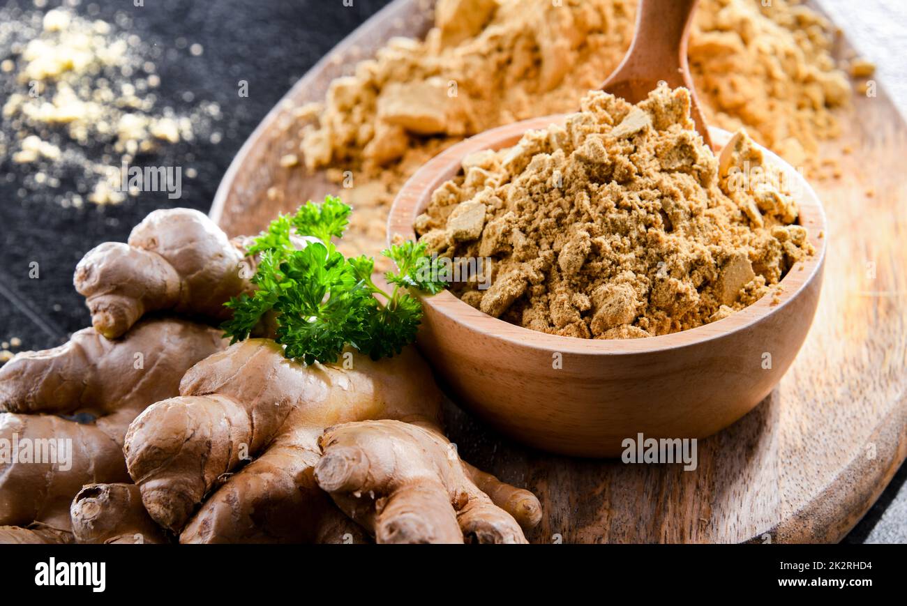 Eine Schüssel mit gemahlenem Ingwer und seinem frischen Rhizom Stockfoto