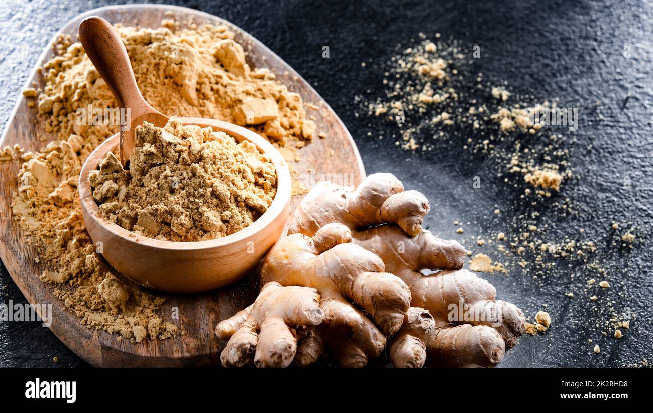 Eine Schüssel mit gemahlenem Ingwer und seinem frischen Rhizom Stockfoto