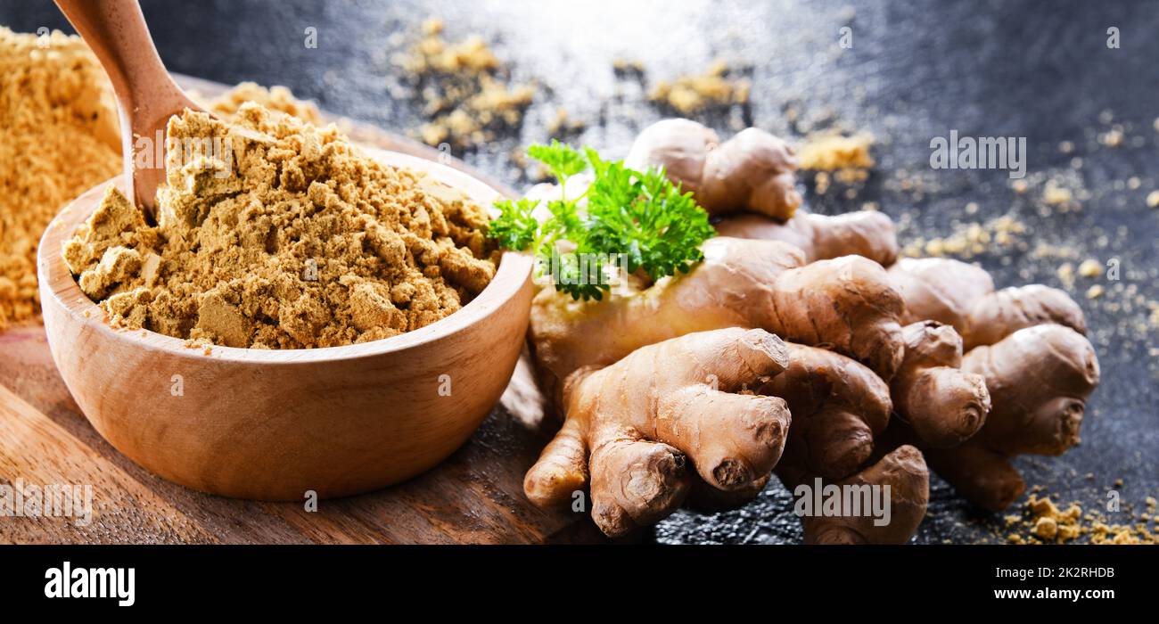 Eine Schüssel mit gemahlenem Ingwer und seinem frischen Rhizom Stockfoto