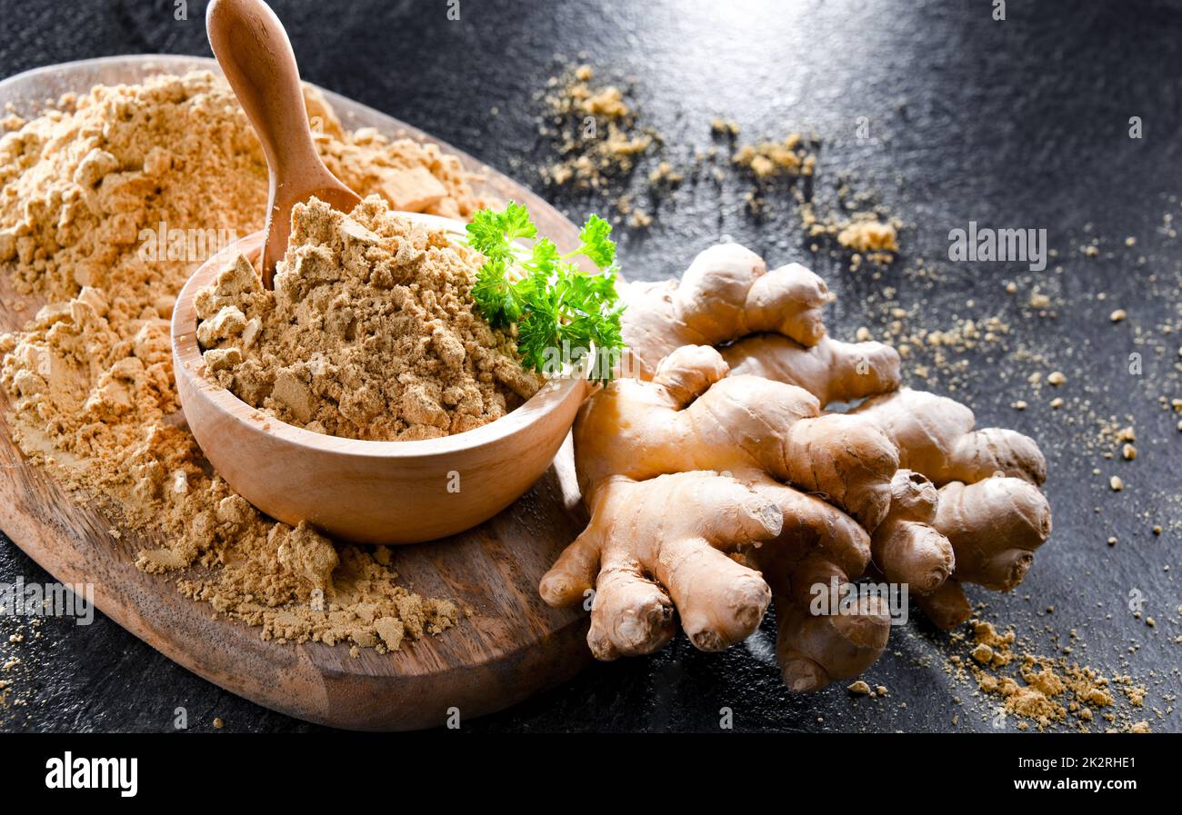 Eine Schüssel mit gemahlenem Ingwer und seinem frischen Rhizom Stockfoto