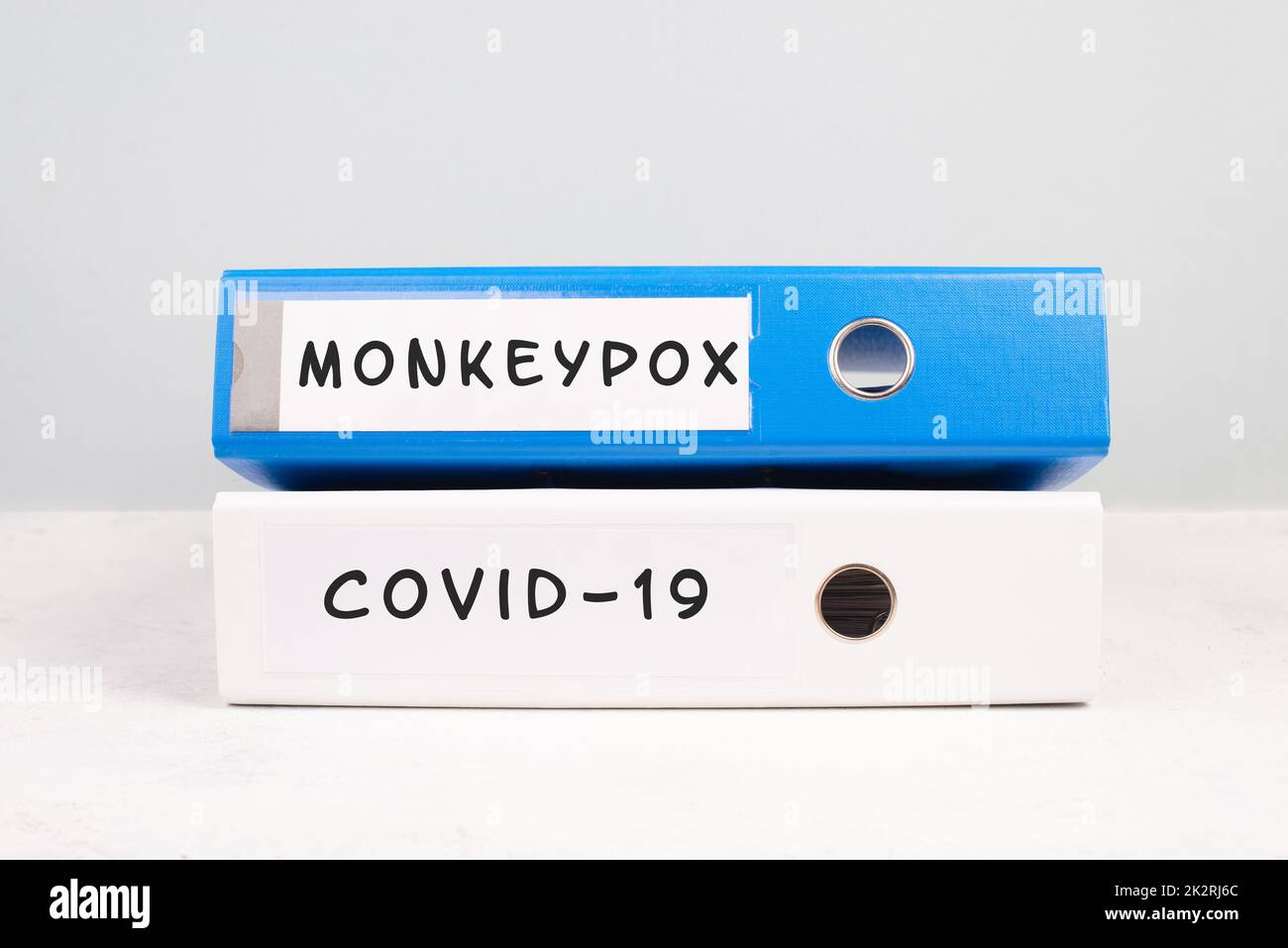 Die Wörter monkeypox und Covid-19 stehen auf einer Mappe, Ausbruch einer Virus-Infektionskrankheit, Verarbeitung der Pandemie, Beweisdokumente Stockfoto