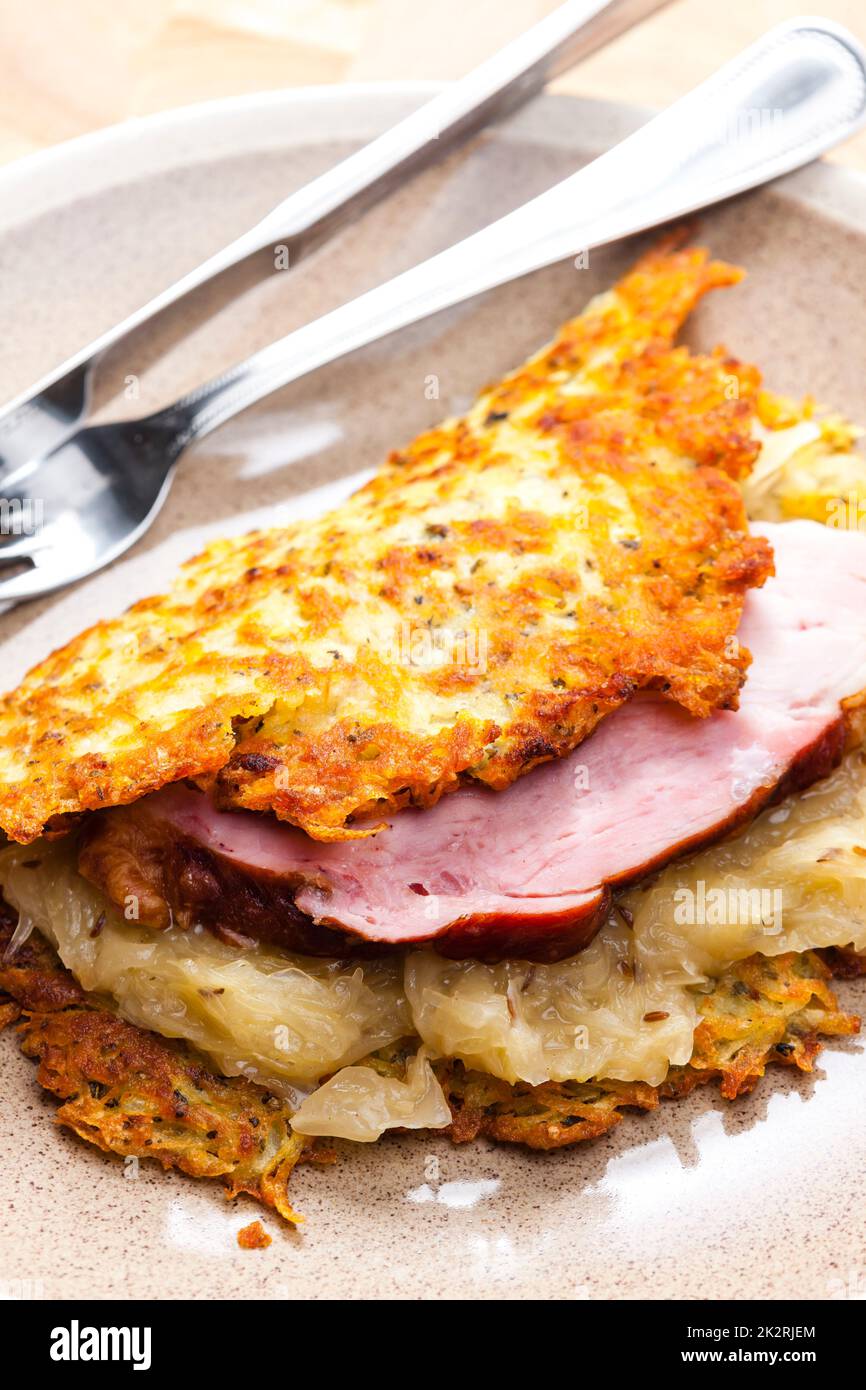 Kartoffelkuchen mit geräuchertem Fleisch und saurem Kohl Stockfoto