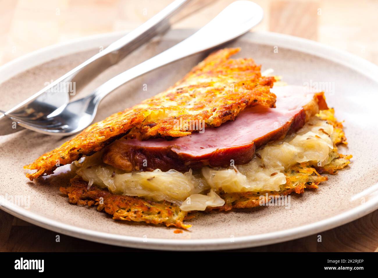 Kartoffelkuchen mit geräuchertem Fleisch und saurem Kohl Stockfoto