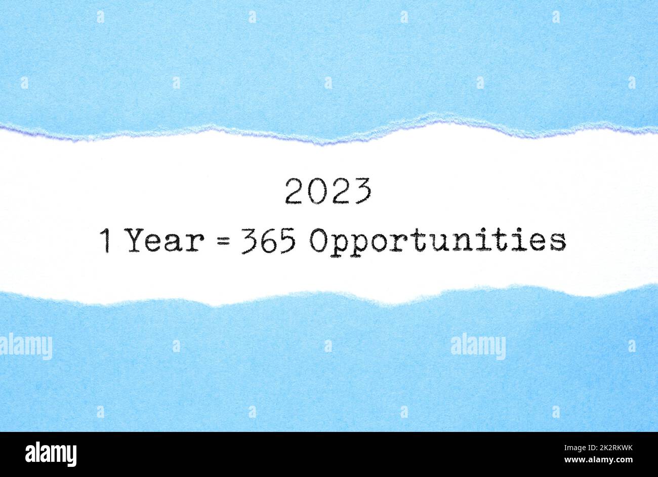 Inspirierendes Zitat 1 Jahr 2023 entspricht 365 Gelegenheiten, die hinter zerrissenem blauem Papier auftauchen. Neues Motivationskonzept. Stockfoto