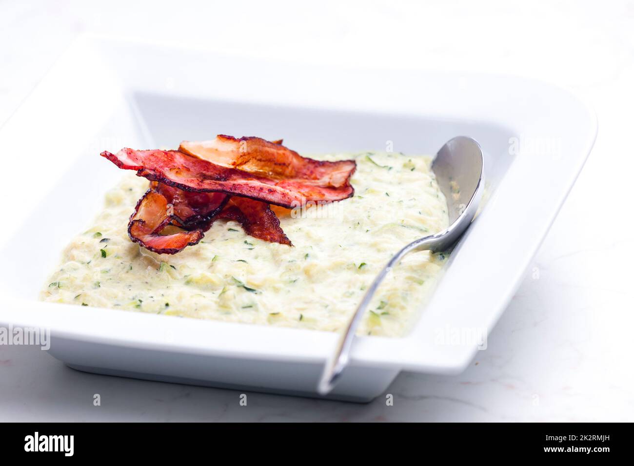 Zucchini-Suppe mit Speckstreifen Stockfoto