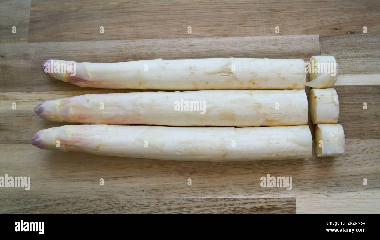 Frischer Spargel mit geschnittenen Enden auf einem Tisch in der Küche Stockfoto