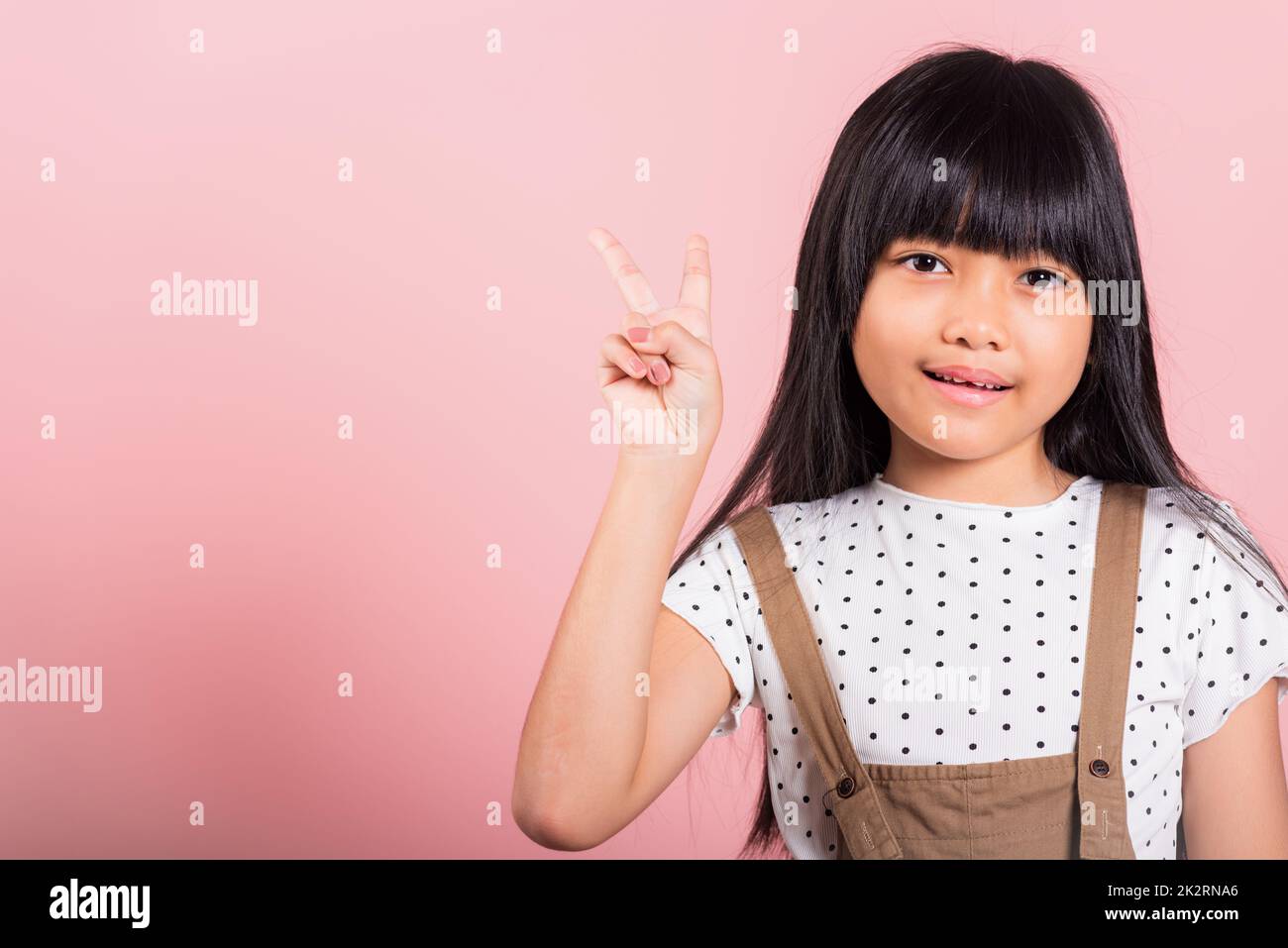 Asiatisches kleines Kind 10 Jahre alt zeigt V-Zeichen-Finger-Geste Stockfoto