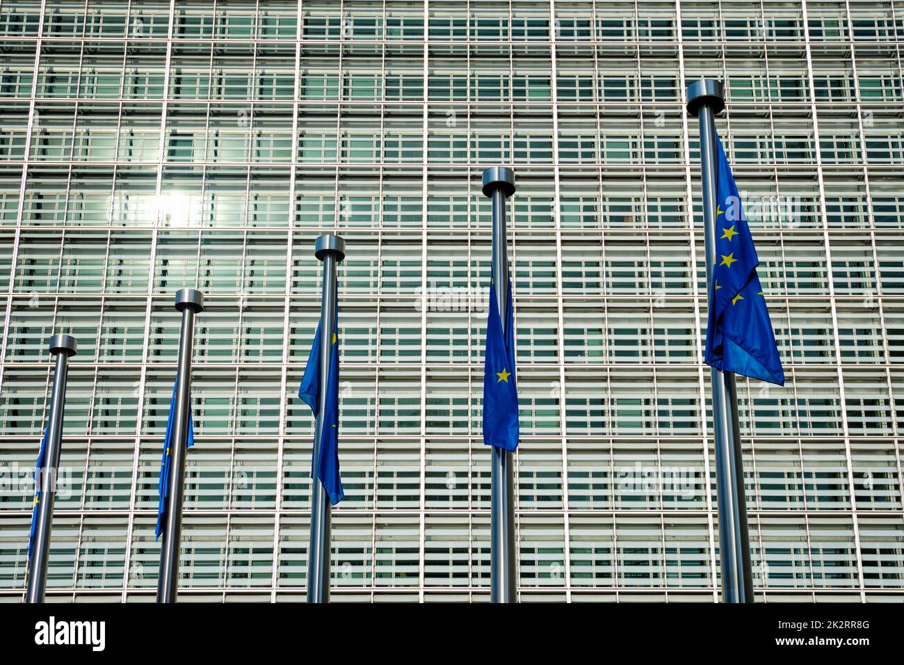 EU-Flaggen der Europäischen Union vor dem Gebäude der Europäischen Kommission im Hintergrund. Brussles, Belgien Stockfoto