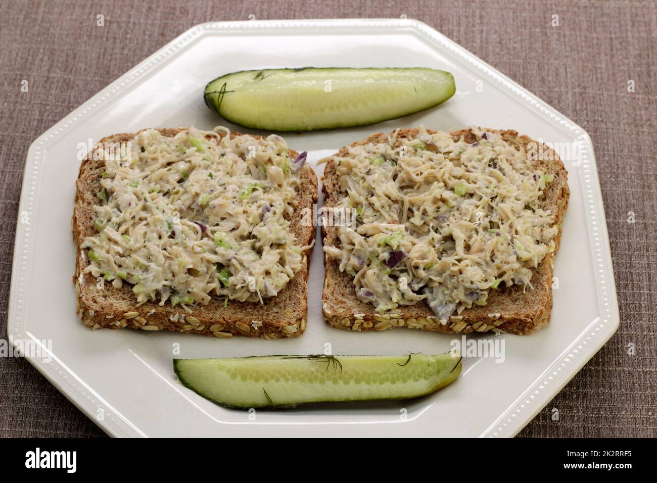 Zwei offene Sandwiches mit Hühnersalat auf einem Teller mit Dill Pickles Stockfoto