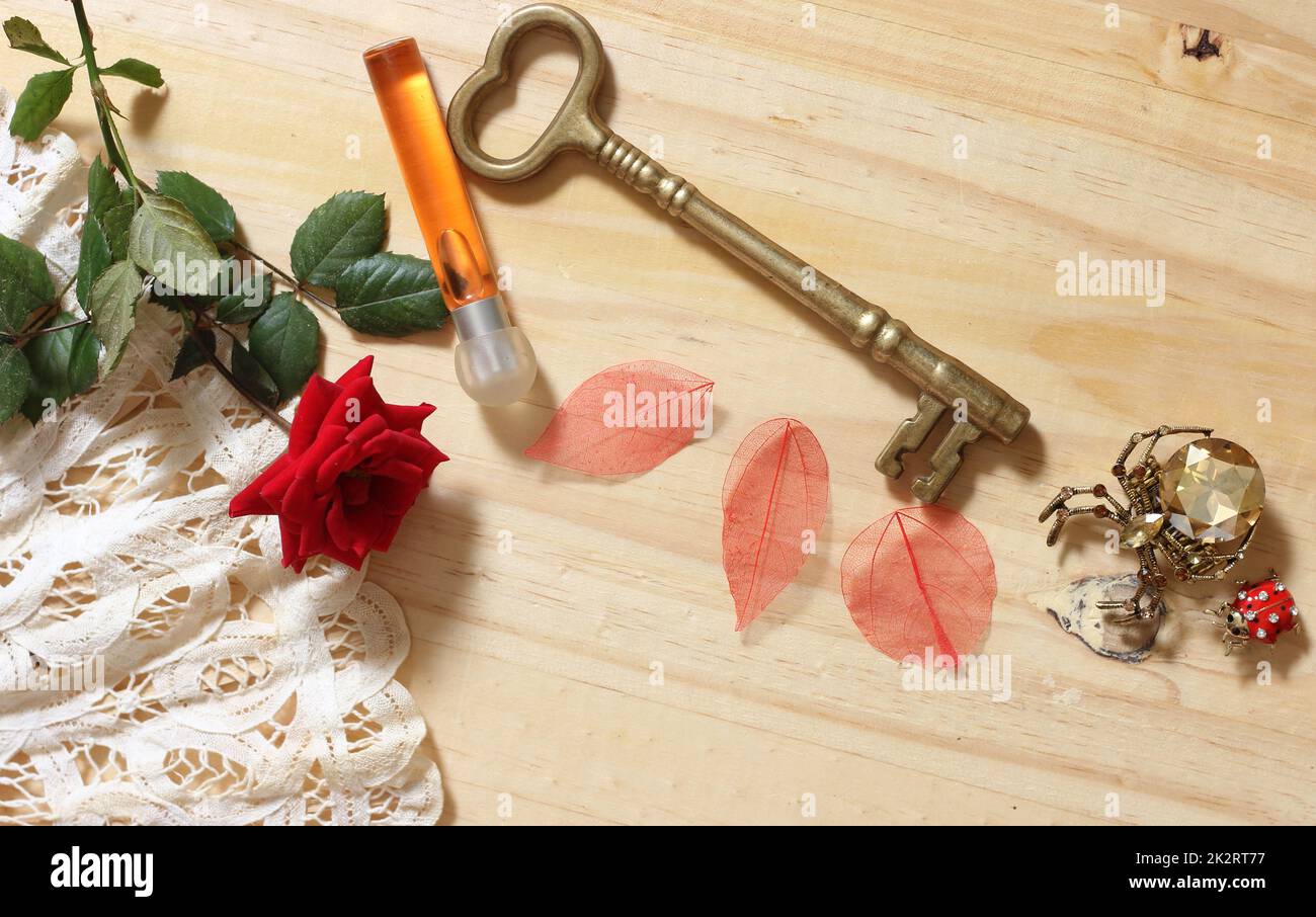 Klassischer Messingschlüssel mit Spitzenventilator und roter Rose Stockfoto
