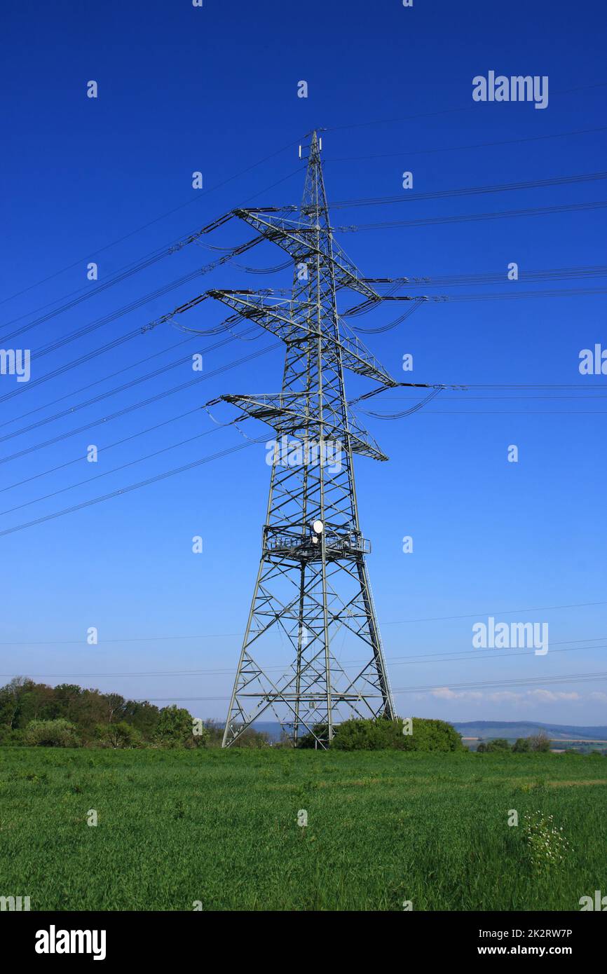 Einzelner Hochspannungs-Pylon gegen einen blauen Himmel Stockfoto