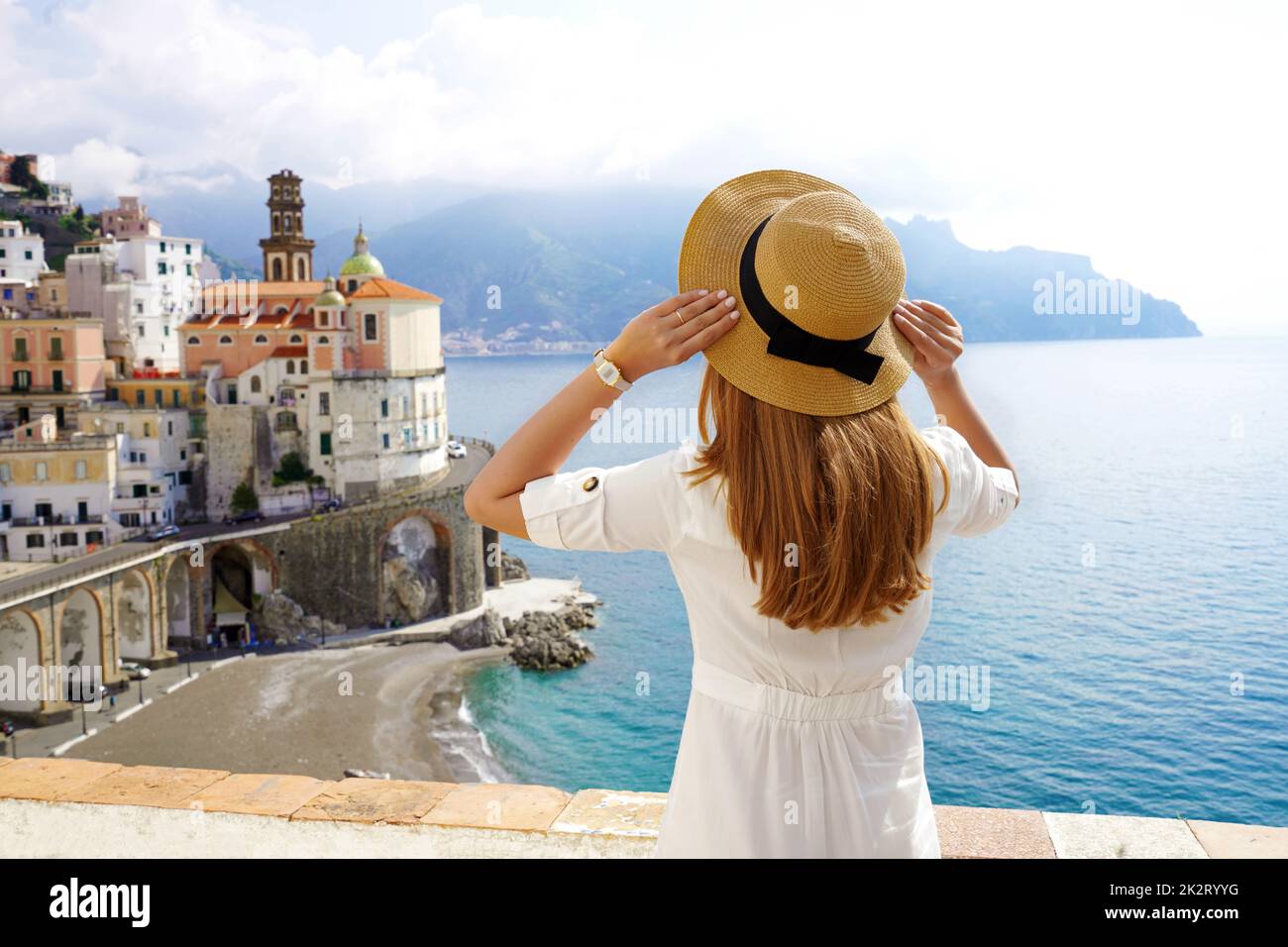 Tourismus in Italien. Rückansicht eines Mädchens mit Hut und Blick auf das Dorf Atrani an der Amalfiküste, Italien. Stockfoto