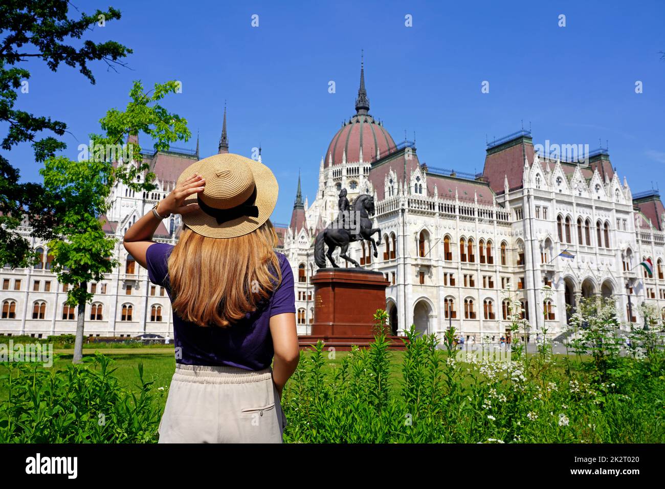 Tourismus in Budapest, Ungarn. Rückansicht des schönen Reisenden Mädchen genießen Blick auf das ungarische Parlamentsgebäude in Budapest, Ungarn. Stockfoto