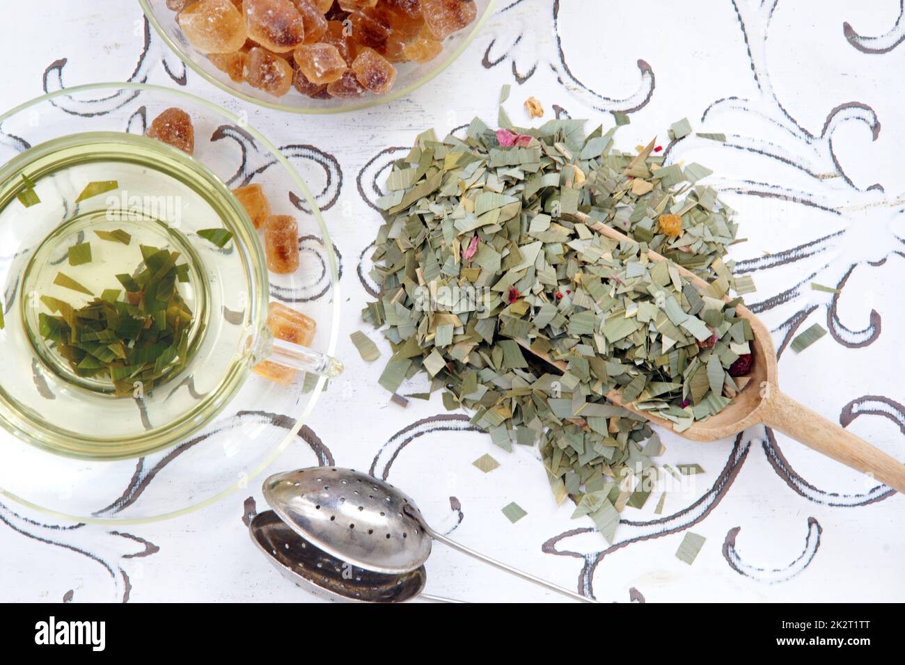 Kräutertee aus Zitronengras in einer Glasschaufel und einem Teesieb Stockfoto