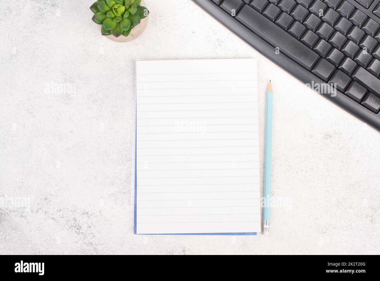Leeres Papier mit einem Stift, einer Computertastatur und einem Kaktus, strukturierter Hintergrund, Brainstorming für neue Ideen, Schreiben einer Nachricht, eine Pause machen, Schreibtisch im Home Office Stockfoto