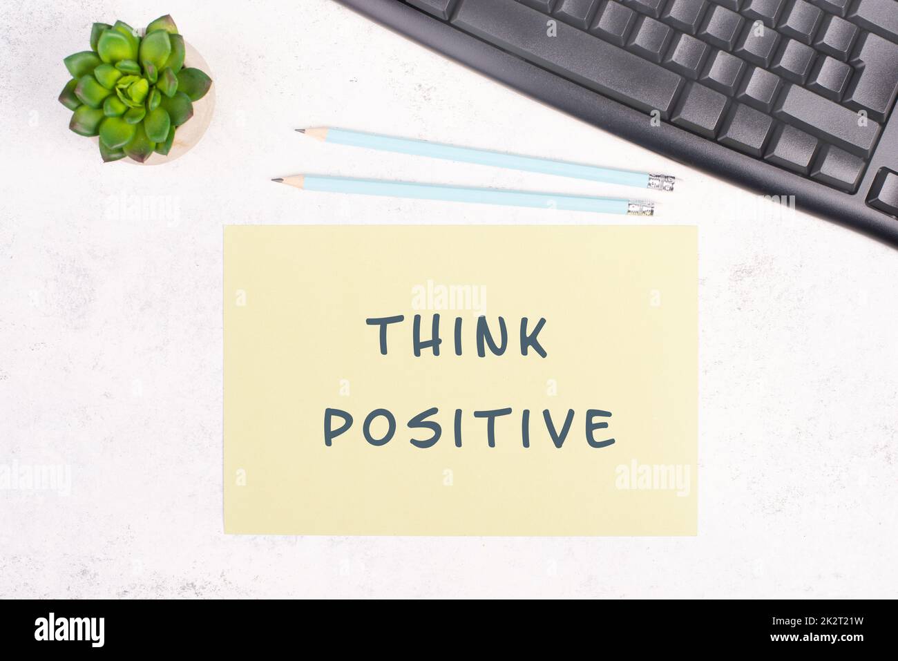 Think positive steht auf einem Papier, einer Computertastatur und einem Kaktus, Brainstorming für neue Ideen, neue Denkansätze, Schreibtisch im Home Office Stockfoto