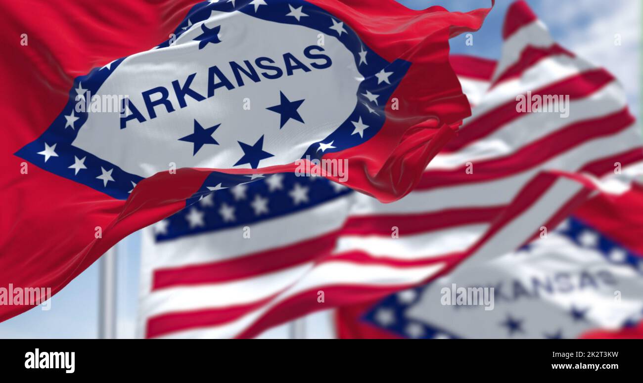 Die Flaggen des Bundesstaates Arkansas und der Vereinigten Staaten winken im Wind. Stockfoto