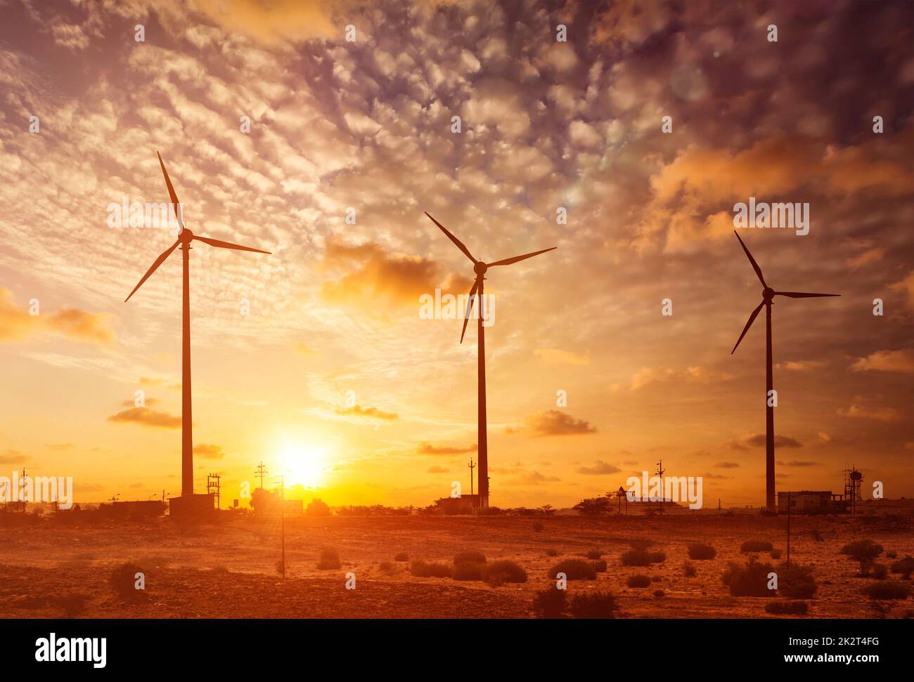 Windgenerator-Turbinen bei Sonnenuntergang Silhouetten Stockfoto