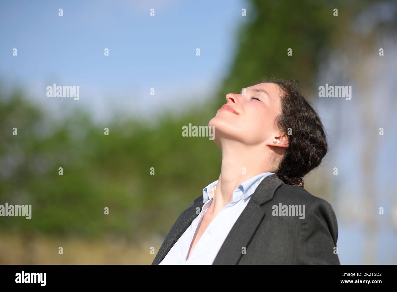 Geschäftsfrau, die sich entspannt und frische Luft in einem Park atmet Stockfoto