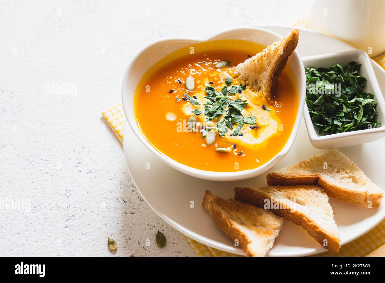 Vegetarische Herbstsuppe mit Kürbis und Karotten mit Sahne und Samen. Comfort Food, Herbst und Winter gesundes Slow Food Konzept Stockfoto