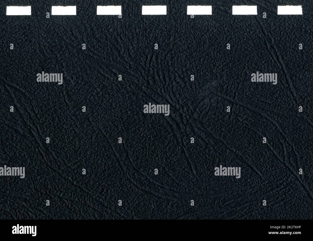 Hochauflösende Nahaufnahme dunkelgraues, schwarzes unbeschichtetes Papier Texturscan mit quadratischen Löchern für Notebook-Cover Spiralbindung Muster Office Notebook-Cover mit Kopierbereich für Text Stockfoto