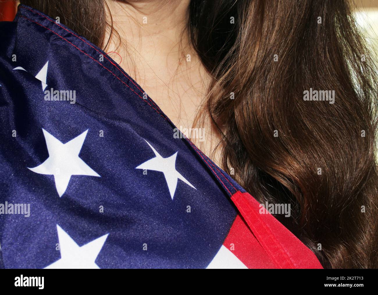 Ein Mädchen mit langen dunklen Haaren hält eine US-Flagge in der Hand Stockfoto