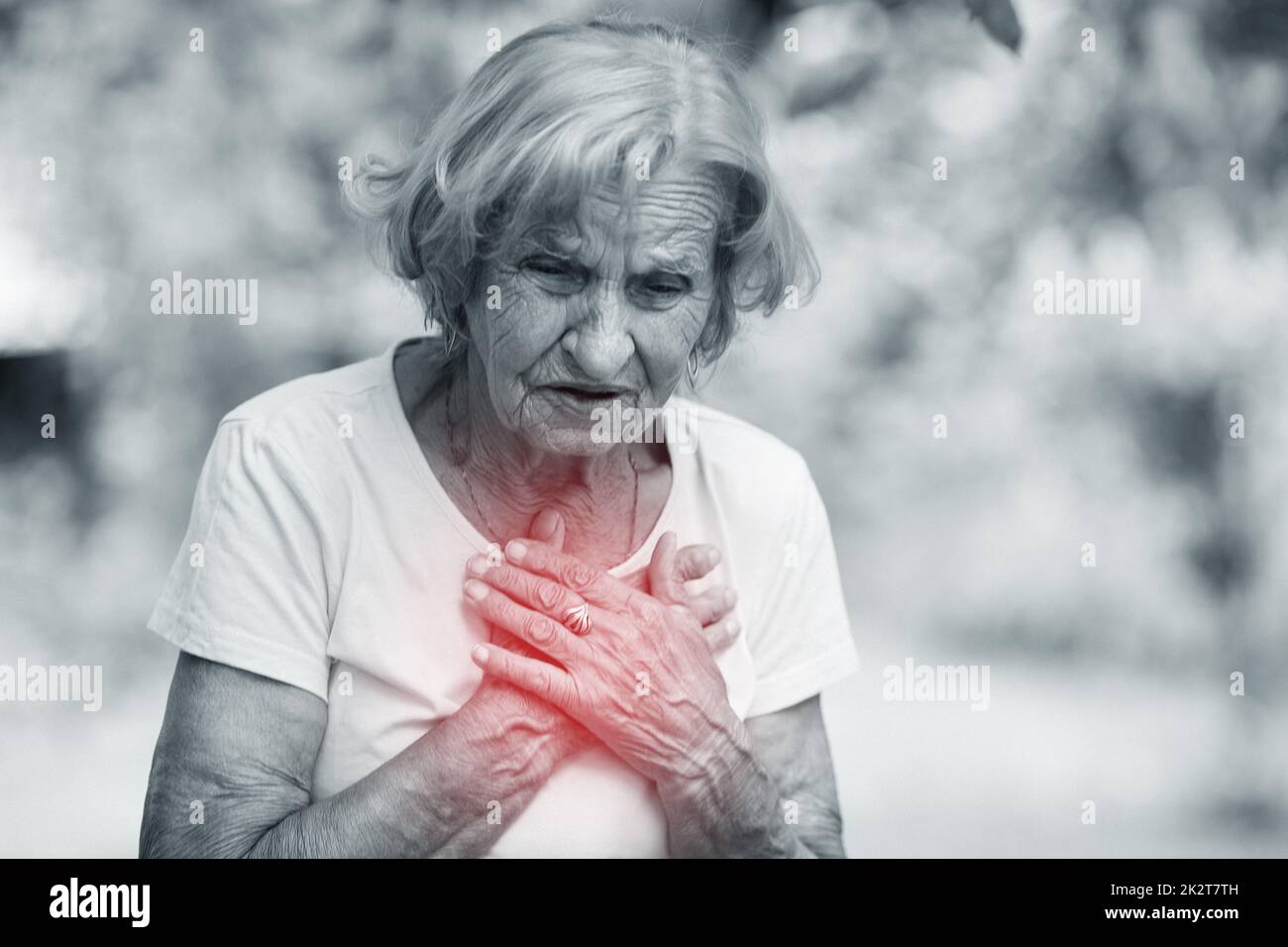 Ältere Frau mit Herzschmerzen, die ihre Brust hält Stockfoto