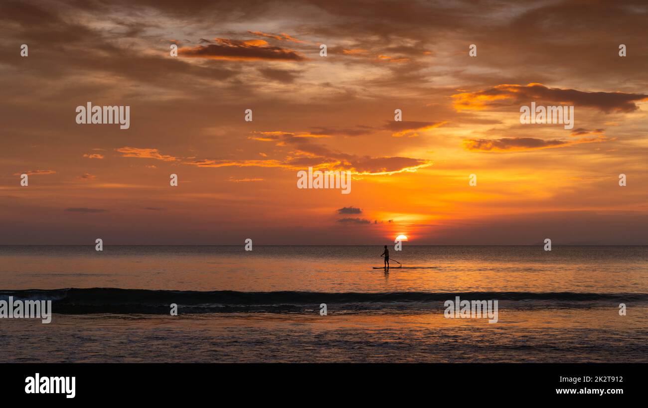Mann beim Surfen im Sommer bei Sonnenuntergang Stockfoto