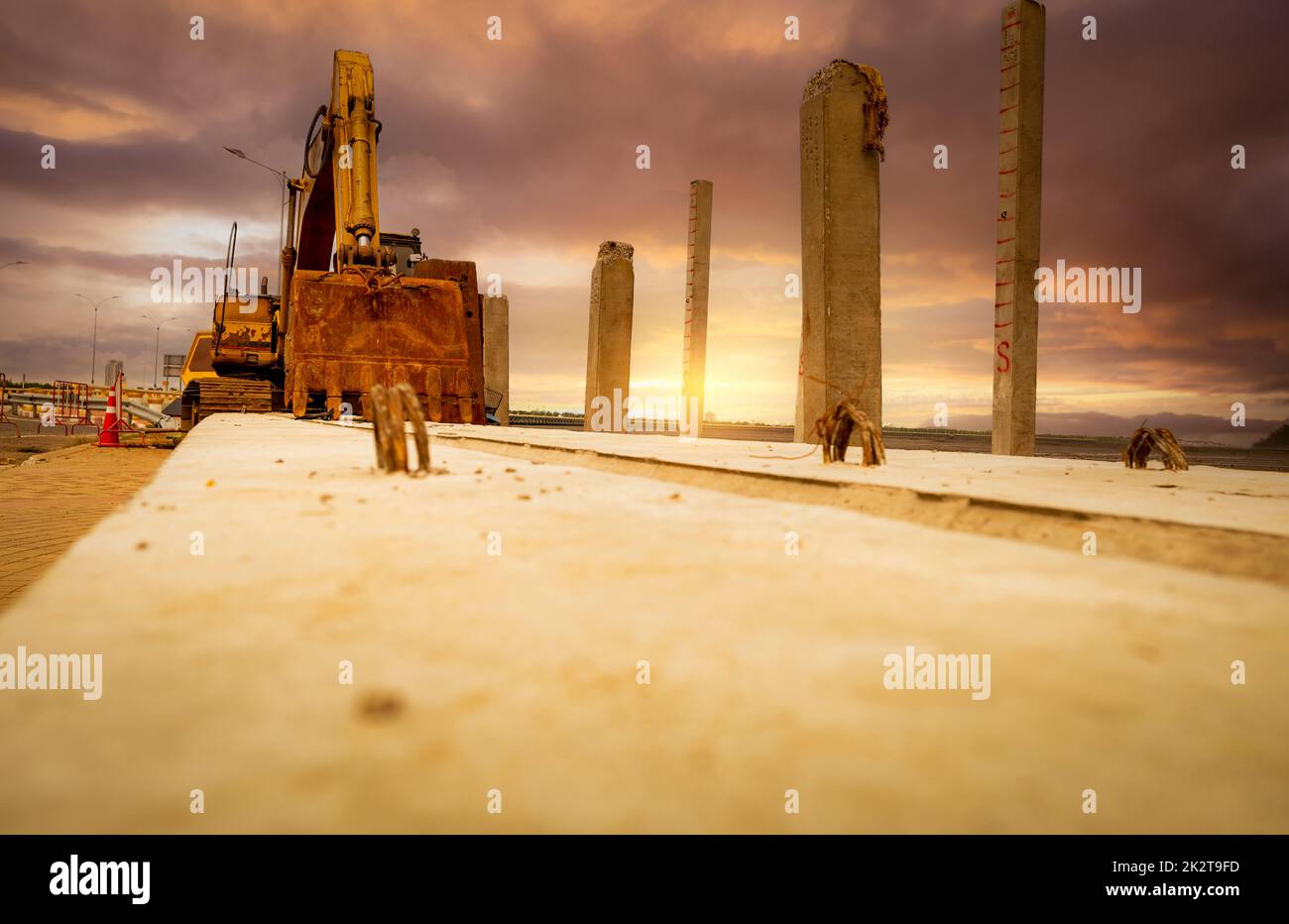Selektiver Fokus auf die Schaufel des alten Baggerladers. Der Graber parkt auf der Baustelle. Bulldozer in der Nähe des Betonmasts. Erdbewegungsmaschine. Gelber Bagger mit Eimer. Erdbewegungsmaschine. Ausgrabungsfahrzeug. Stockfoto
