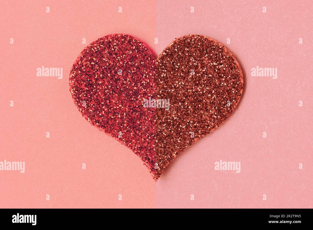 Ein glitzerndes rotes Herz auf Papierhintergrund Stockfoto