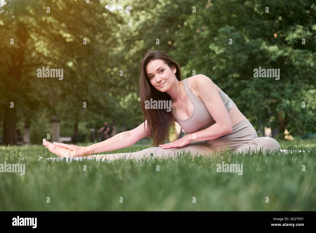 Ein hübsches Mädchen mit einer schlanken Figur und langen Haaren geht an einem warmen Sommertag in den Park, um Sport zu treiben. Stockfoto