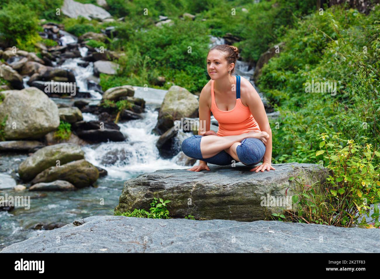 Frau, die Ashtanga Vinyasa Yoga Arm Balance asana Tolasana macht Stockfoto