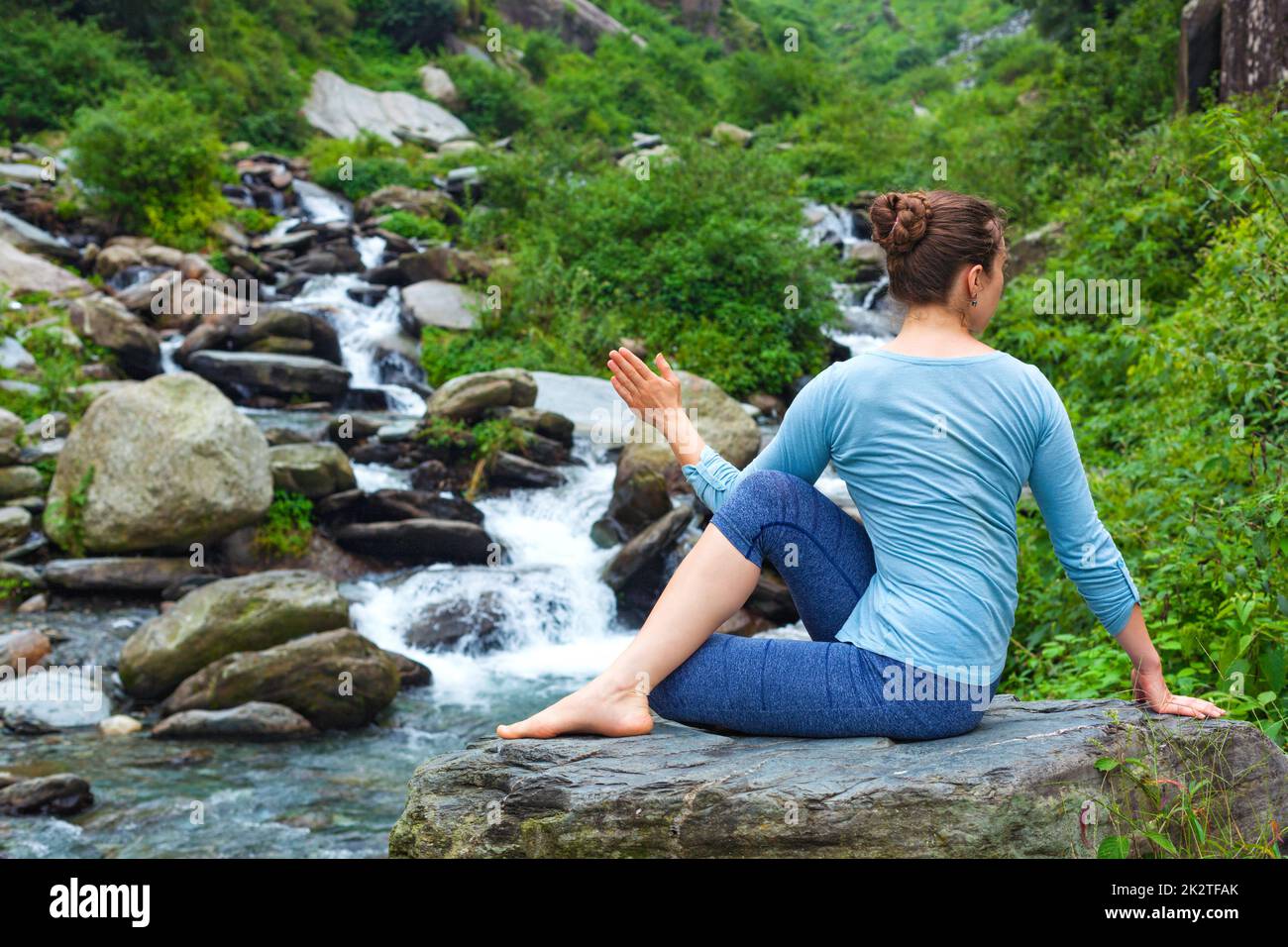 Frau tut Ardha Matsyendrasana Asana im freien Stockfoto