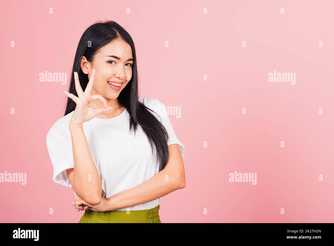 Die Frau stand und machte ein Zeichen mit dem Finger, um zuzustimmen Stockfoto