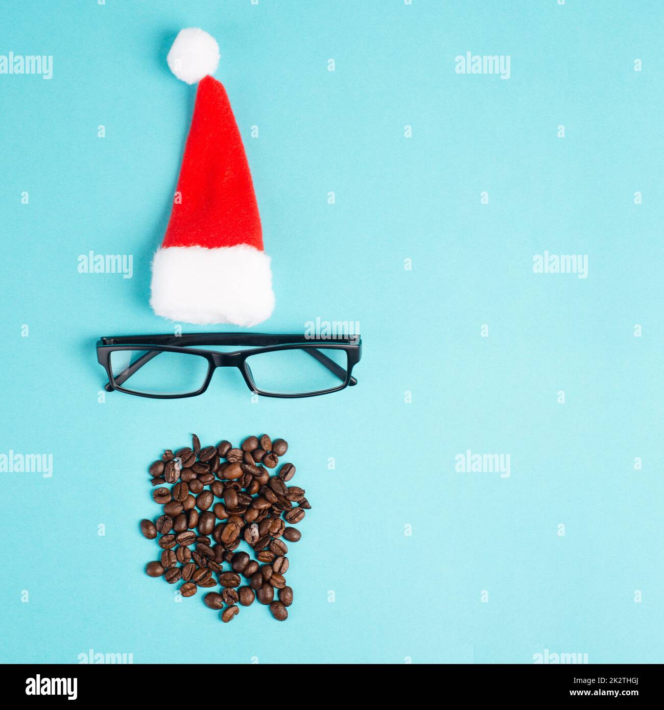 Weihnachtszeit, roter Weihnachtsmann Hut, Brillen, Bart mit Kaffeebohnen, lustiges Gesicht, Winterzeit, Weihnachtskarte, blauer Hintergrund Stockfoto