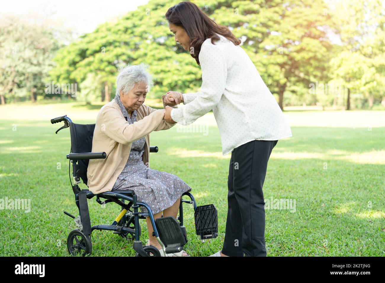 Pflegepersonal Hilfe und Pflege Asiatische ältere oder ältere alte Dame Frau Patientin sitzt und glücklich auf Rollstuhl im Park, gesund starke medizinische Konzept. Stockfoto