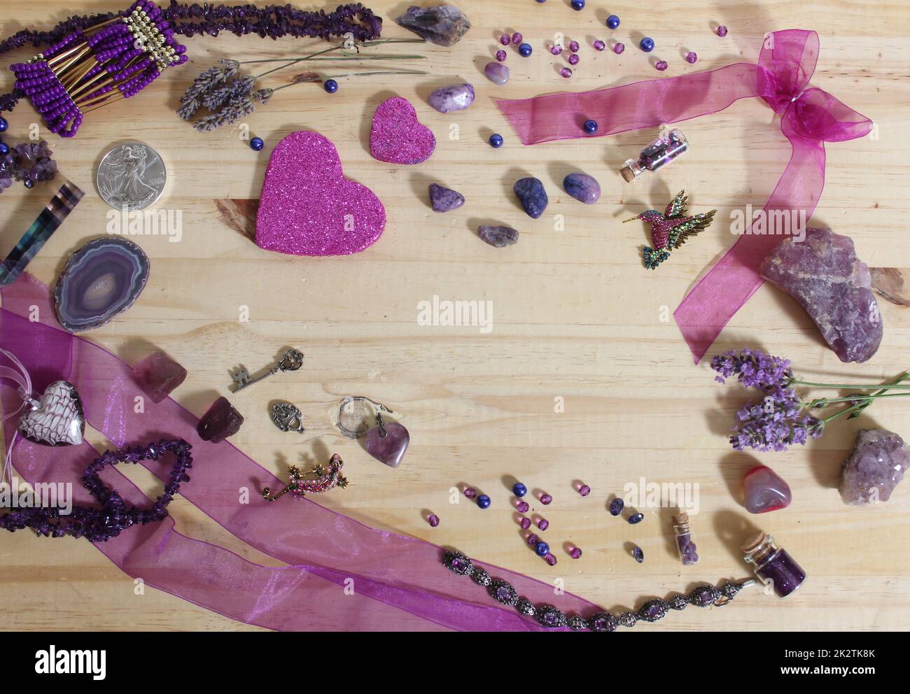 Lila und rosafarbener Schmuck mit glitzernden Herzen und Amethyst Stones auf Holzhintergrund Stockfoto
