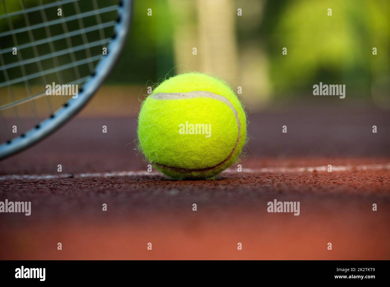 Gelber Tennisball in der Nähe von Schläger und weißer Linie Stockfoto