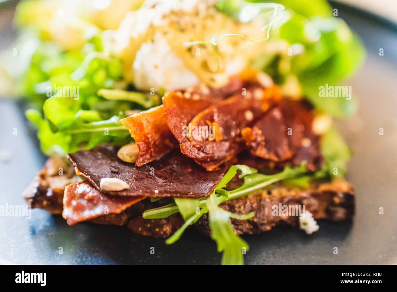 Selektivfokus von Sandwich mit getrocknetem Jamon und Rucola Stockfoto