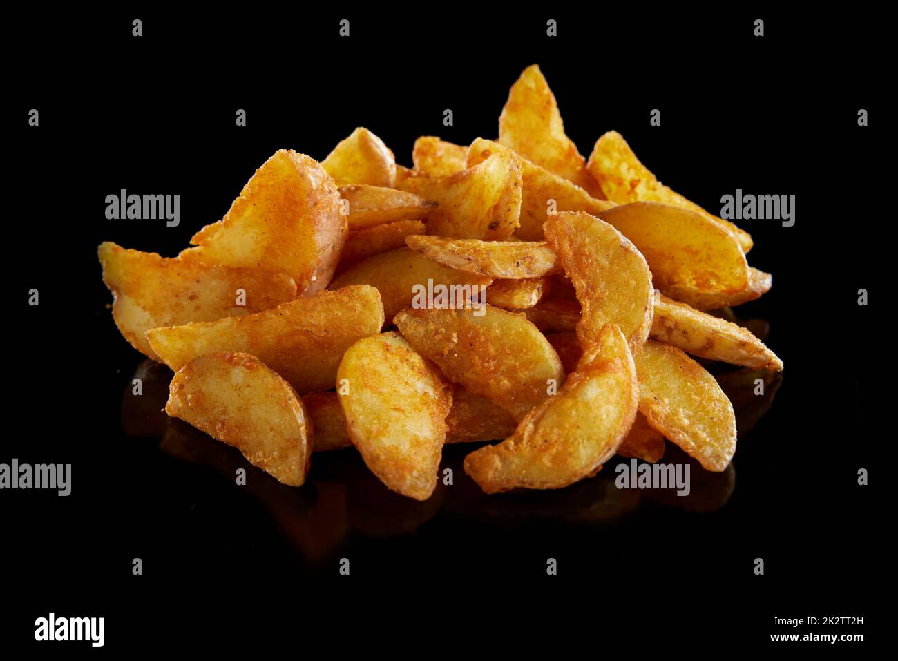 Ein Haufen leckerer frittierter Kartoffeln auf einem schwarzen Tisch Stockfoto
