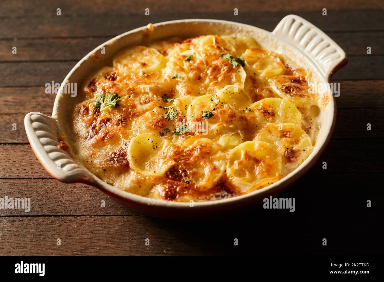 Köstliche gebackene Kartoffel mit Käse in Keramikschale Stockfoto