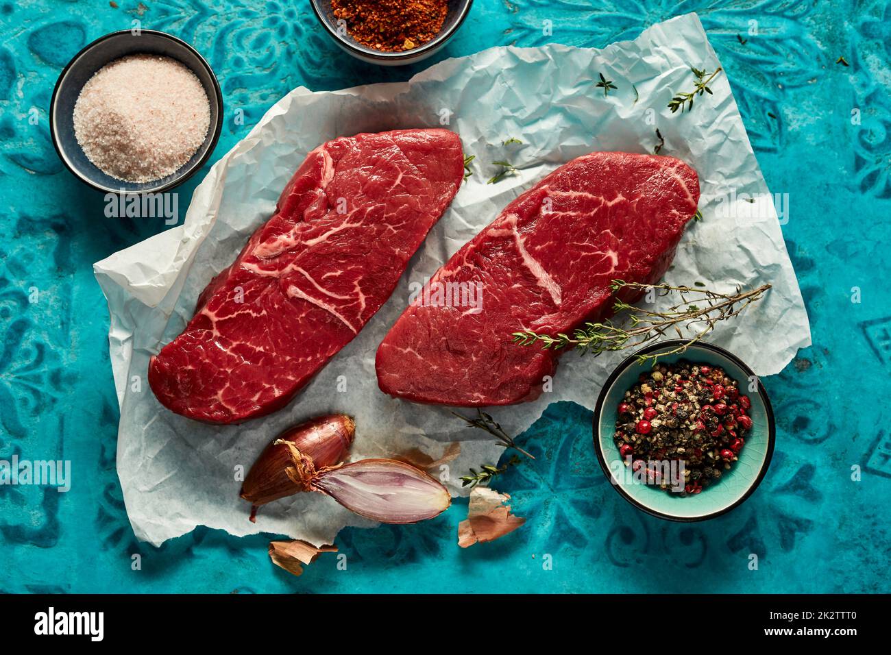 Rohes New Yorker Steak mit Gewürzen auf Pergament Stockfoto