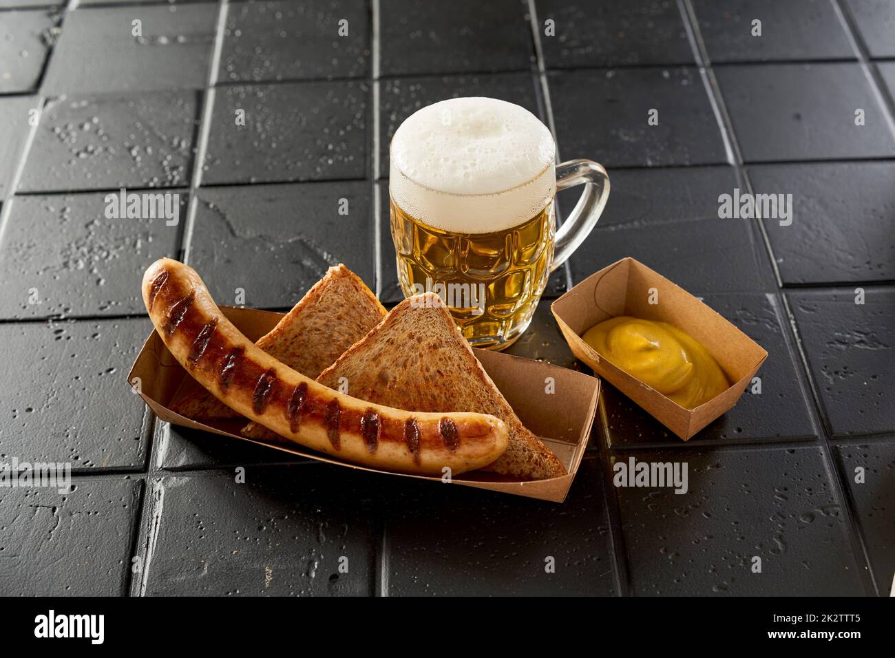 Heiße Wurst neben einem Glas Bier Stockfoto